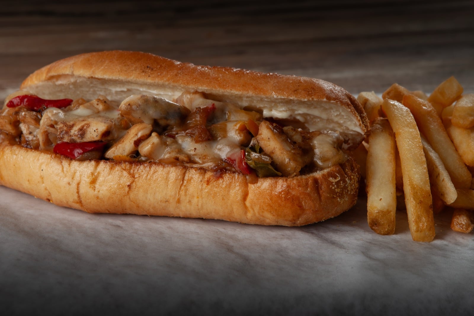 A chicken Philly cheesesteak with fries