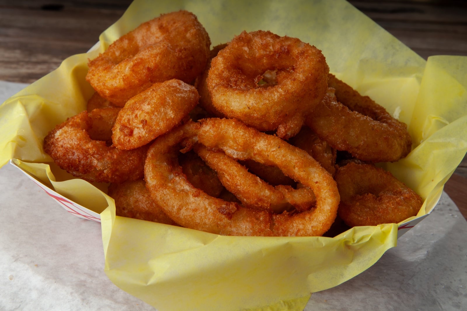 Beer battered onion rings stacked on a plate